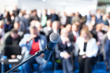 Microphone in focus against blurred audience